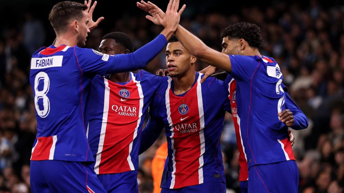 Paris Saint-Germain players celebrate a goal during their 4-2 UEFA Champions League win over Barcelona, as Maghnes Akliouche embraces Lucas Hernández and João Neves joins in behind them.